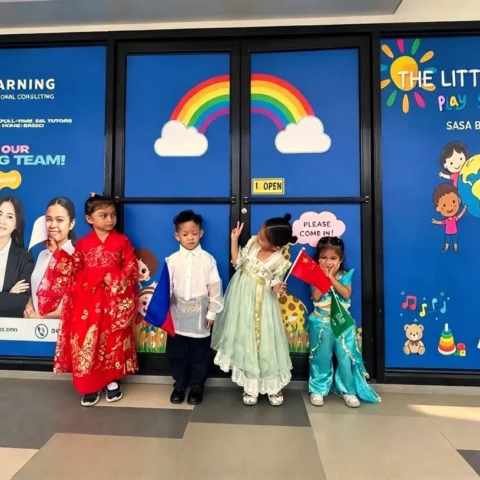Preschoolers in United Nations Day costumes posing outside the playschool's rainbow-decorated entrance in Sasa, Davao City